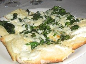 Grilled flat bread with goat cheese, broccoli rabe, red pepper oil and mozzarella